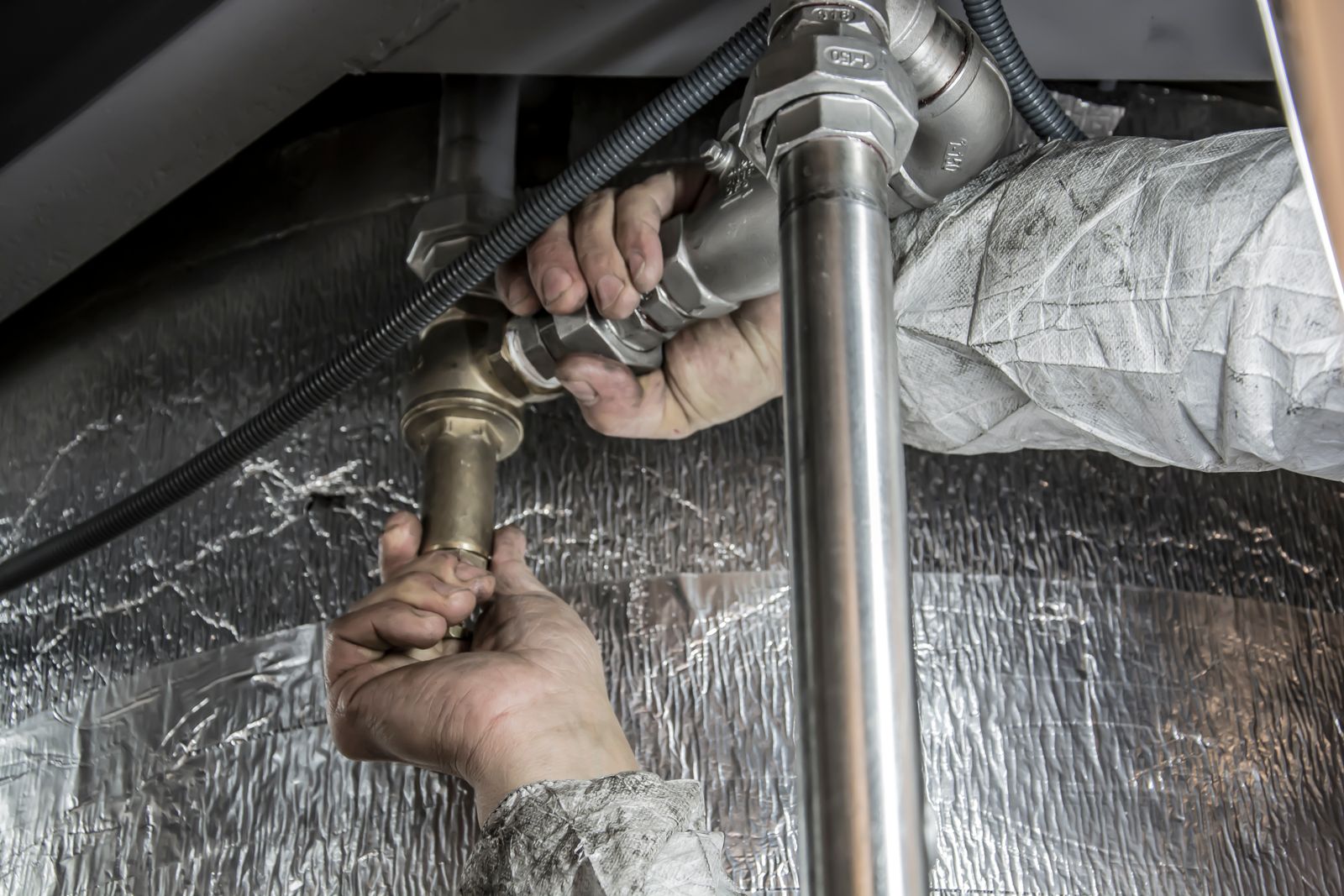 Gloved hands installing a steel water line